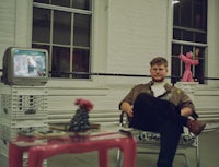 a man sitting in a chair in front of a television